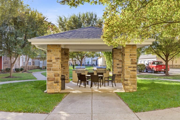 Outdoor patio community amenities with two stainless steel grills and seating